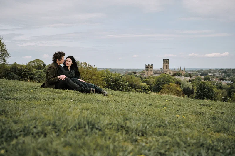 A relaxed portrait of the engaged couple sitting on Observatory Hill