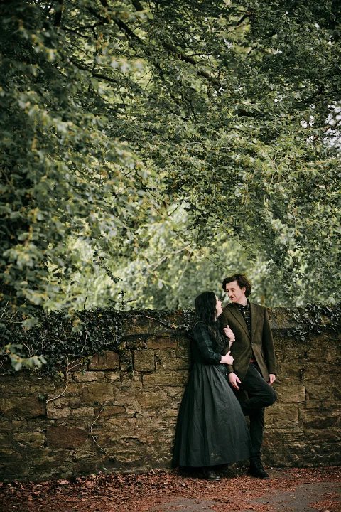 A full length portrait of the newly engaged couple among the trees