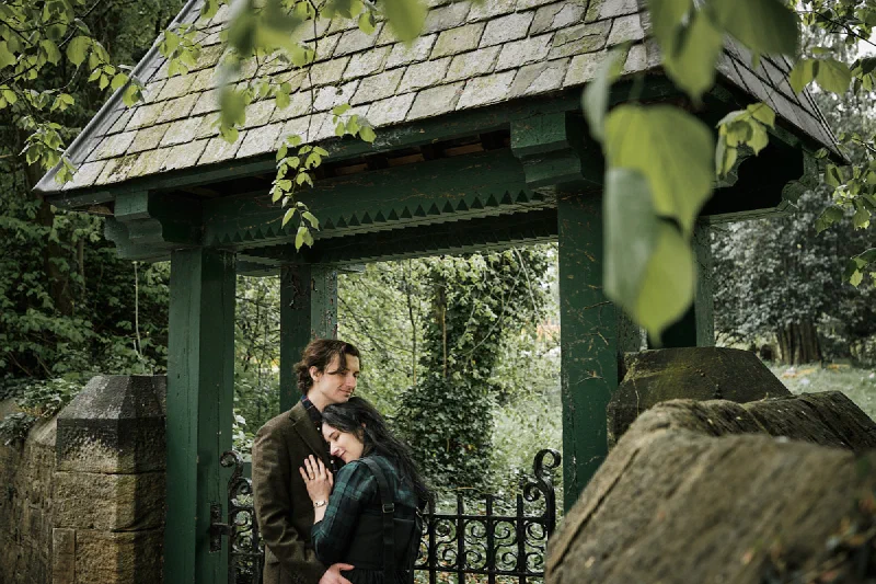 The couple sharing a kiss beneath a stone shelter in Durham