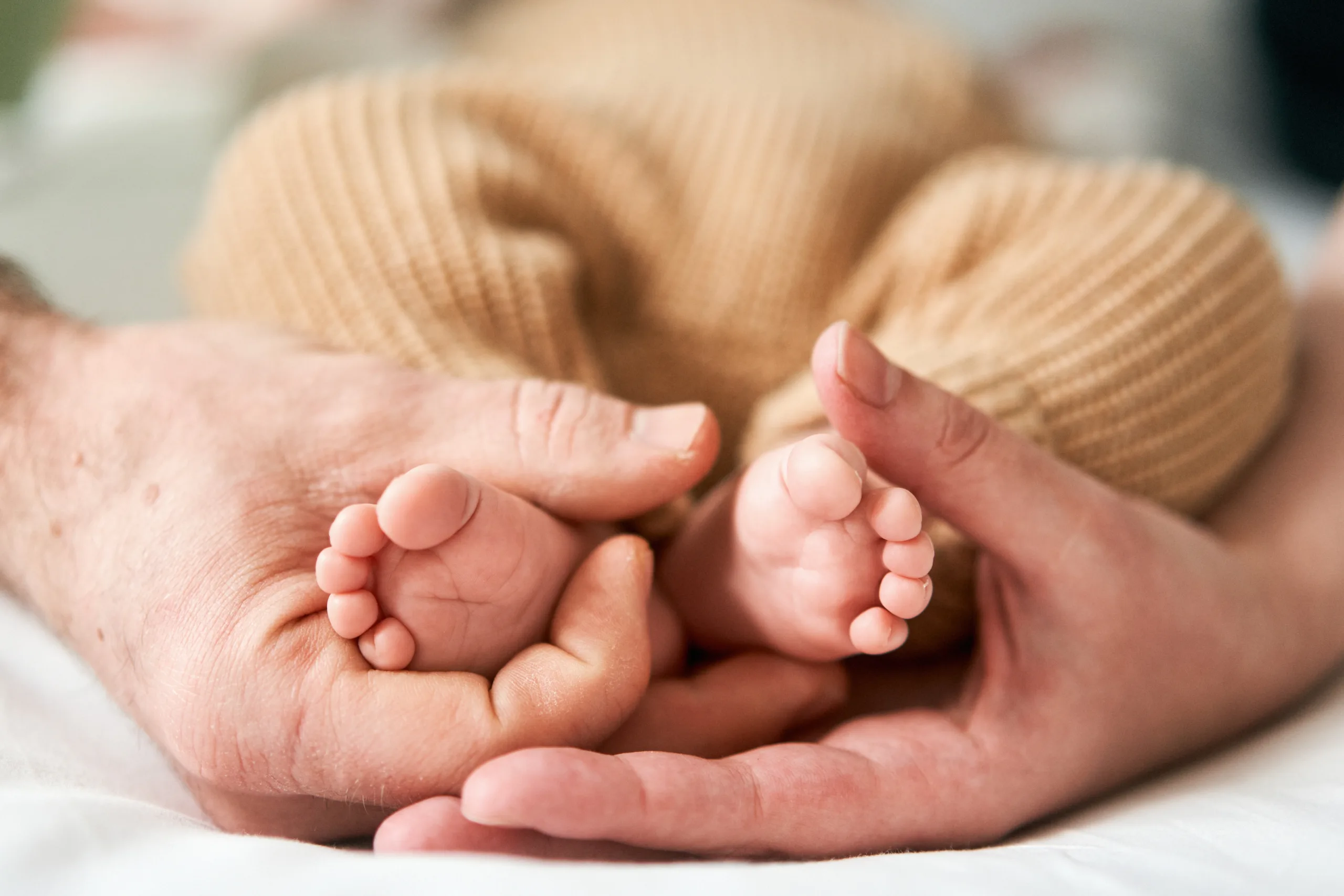 At-home newborn photographer Newcastle cuddling baby